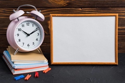White blank board alarm clock clothes peg notebooks black desk
