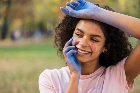 Woman smiling with hands covered blue powder