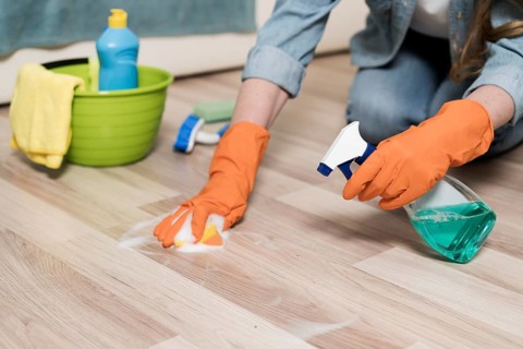 Woman with rubber gloves cleaning floors