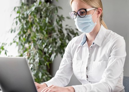 Young woman doing her classes while wearing face mask