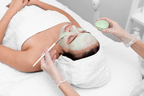Beautician applying face mask female client 7