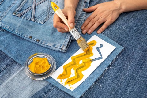 Close up hand painting jeans