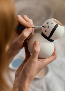 Close up hands painting pottery item