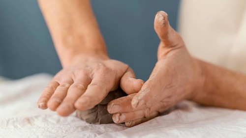 Close up hands shaping clay