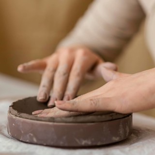 Close up hands touching clay
