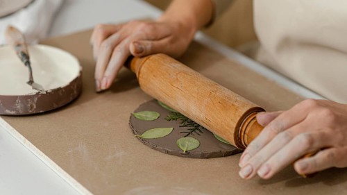 Close up hands using rolling pin