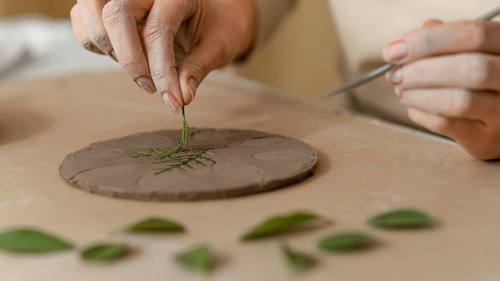 Close up hands working with plant clay