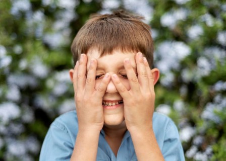 Close up kid covering his face