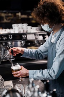 Close up man with mask pouring beer