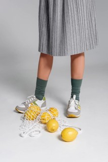 Close up turtle bag with lemons beside woman feet