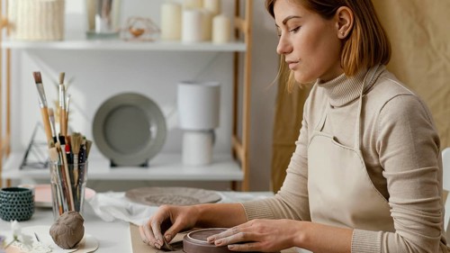 Close up woman doing pottery home