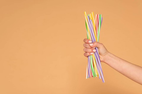 Close up woman hand with plastic straws