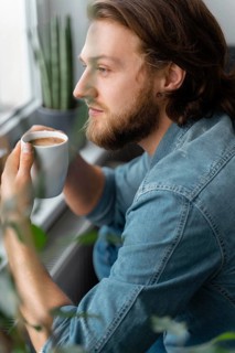 Man holding coffee cup close up