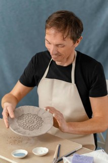 Medium shot smiley man doing pottery
