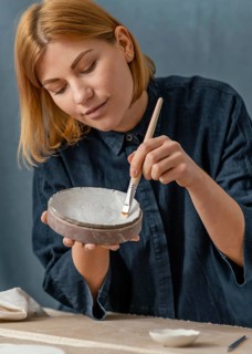 Medium shot woman painting vase