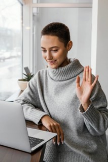 Medium shot woman waving laptop