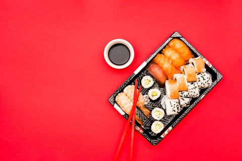 Sushi rolls sashimi tray with soy sauce colored background