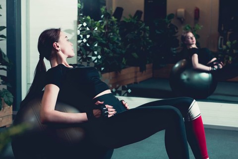 Women doing sit ups exercise balls gym