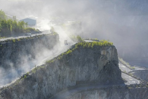 Trucks driving in dusty porphyry quarry
