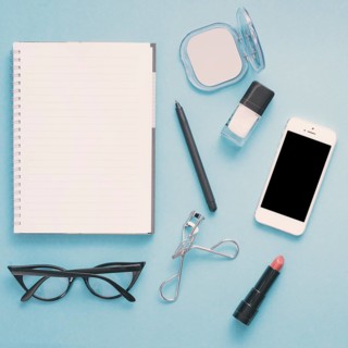 Smartphone with notebook cosmetics blue table