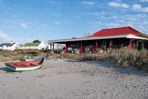 Fishing boat in front of beach restaurant