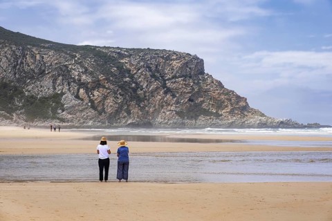 Tourists walking on Nature's Valley sandy beach in the Tsitsikamma Section of the Garden Route National Park