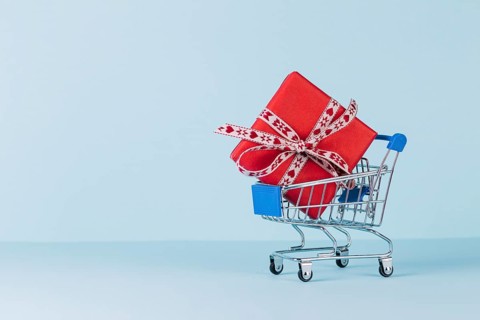 Wrapped red gift box shopping cart blue background