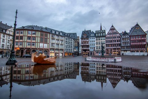 Reflection in a puddle between a historic city centre. Cityscape at the Roemer and the historic houses and streets. Cityscape in Frankfurt am Main