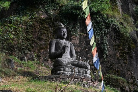 Buddha statue and Tibetan prayer flags in front of the entrance to the Messner Mountain Museum near Bolzano