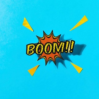 Pop art comics boom speech bubble against blue backdrop