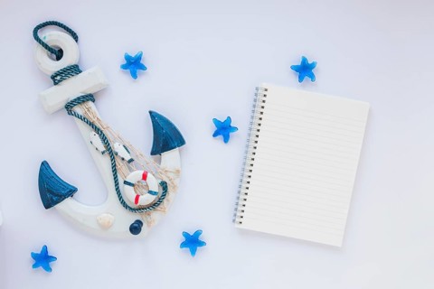 Small wooden anchor with blank notebook