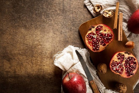 Top view autumn pomegranates with copy space cinnamon sticks