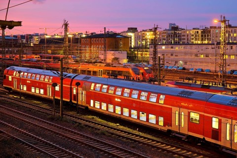 Elevated view of a double-decker commuter train at sunset