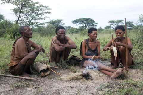 Bushmen cooking roots on handmade fire in the Kalahari desert near Ghanzi
