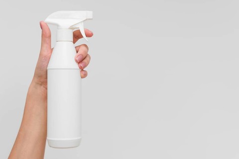 Hand holding disinfectant bottle with copy space