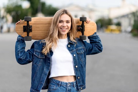 Medium shot woman holding skateboard