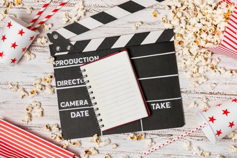 Spiral notepad clapperboard drinking straw popcorns wooden desk