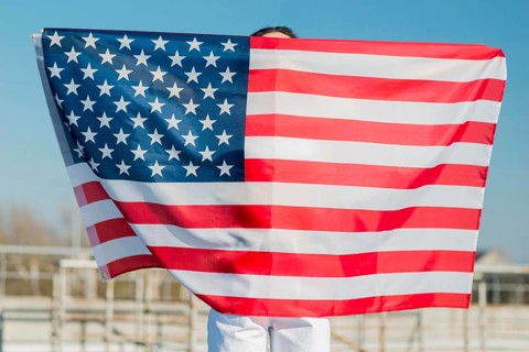Woman holding big usa flag herself