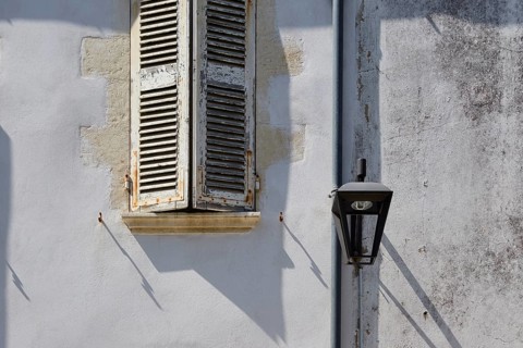 Old shutters and lantern on a facade in Le Chateau-d'Oleron