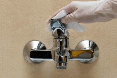 Hand with glove disinfecting faucet