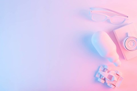 Overhead view lightbulb spectacles formula one car camera against pink backdrop with blue light