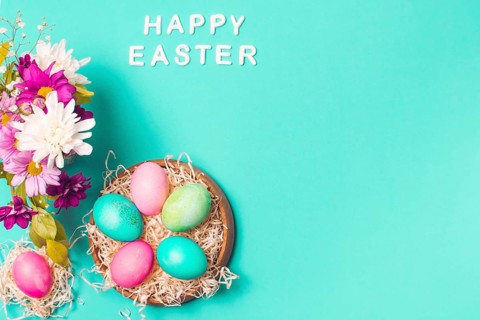 Happy easter title near bright eggs plate flower bouquet