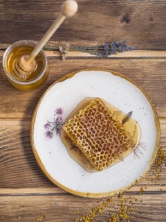 Lavender honey pot with wooden honey dipper bee pollens wooden table