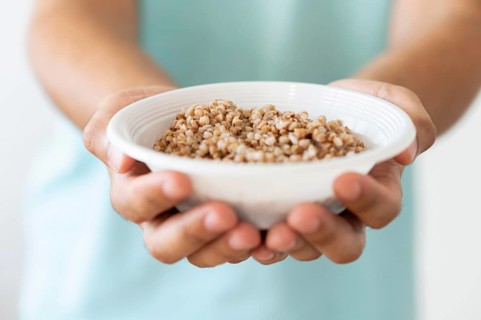 Needy person holding bowl food