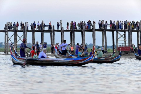 Locals and tourists on a teak bridge