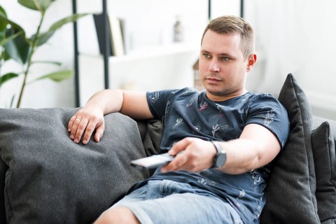Mid adult man sitting sofa watching tv