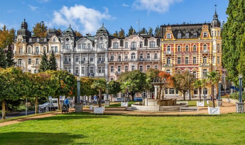 Row of houses with Art Nouveau facades by the autumnal spa park
