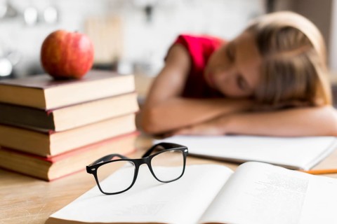 Tired schoolgirl sleeping desk