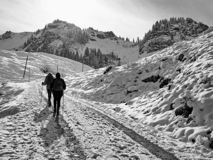 Two female hikers climbing up to the Bodenschneidhaus in winter