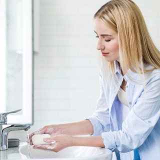 Side view woman washing her hands with bar soap